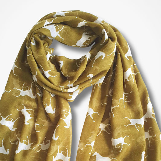 A yellow green scarf with a white silhouette pattern of running horses, styled in a loose knot against a plain white background.