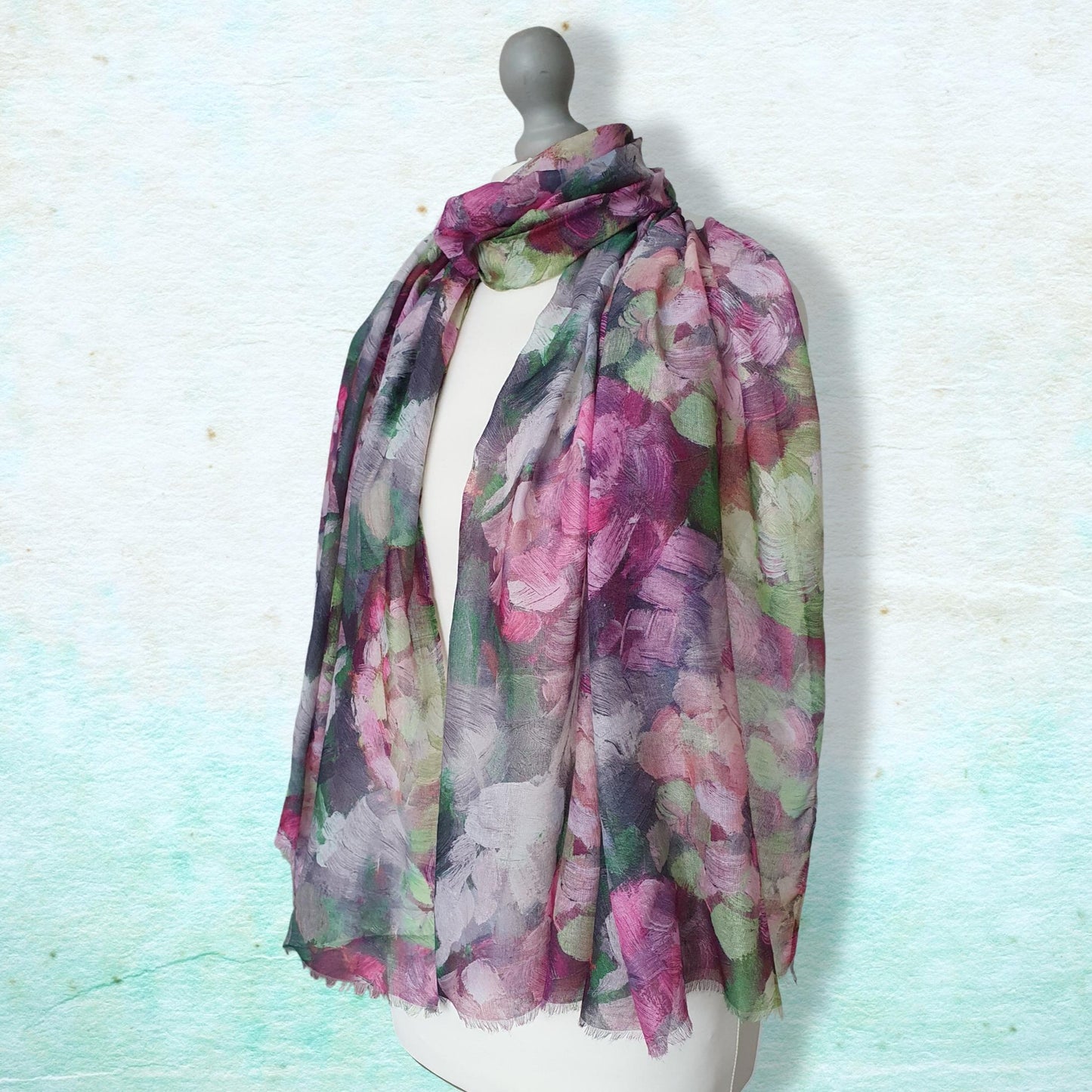 Multicolored floral scarf on a mannequin against a light blue background