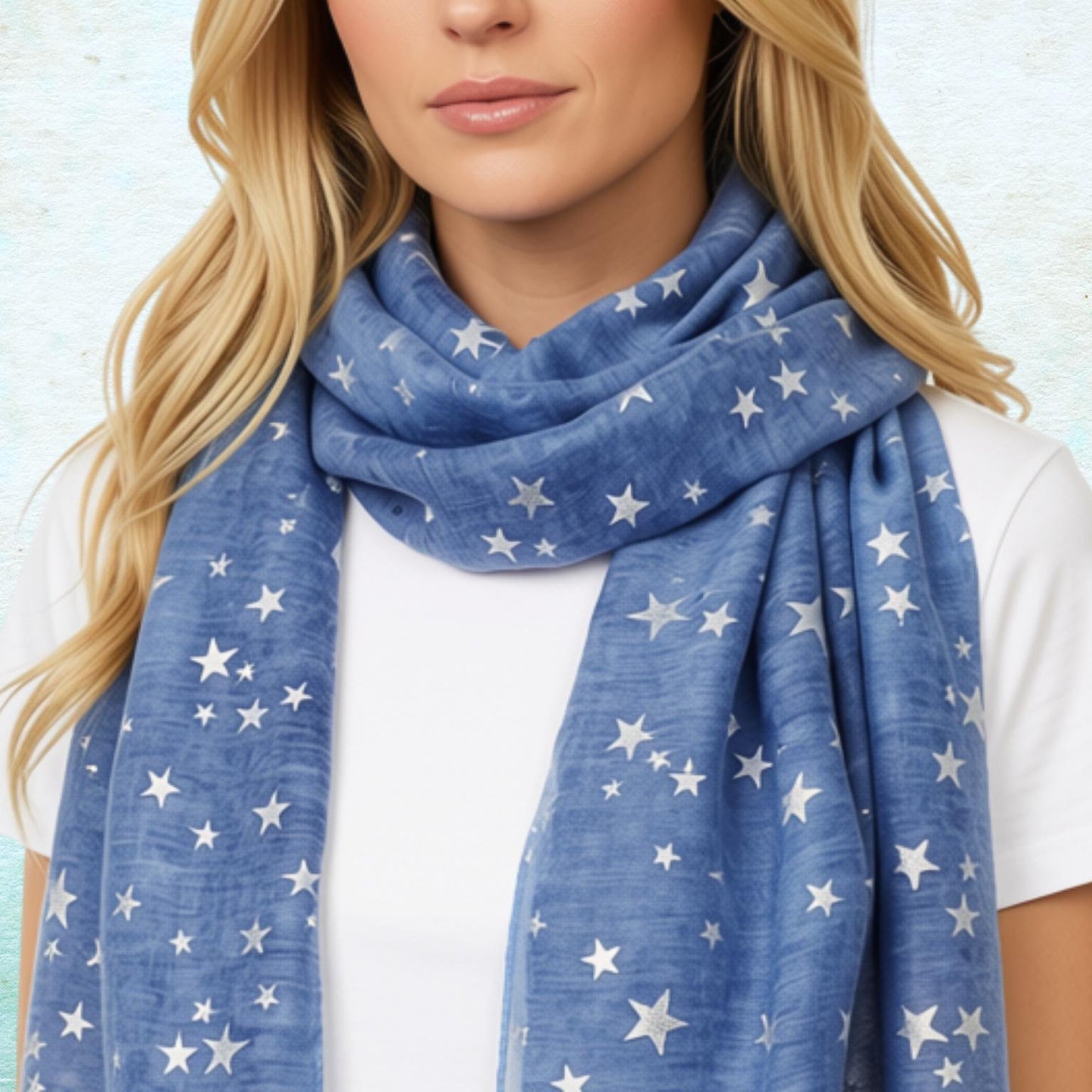 A woman wearing a blue scarf with a silver star pattern, styled over a white t-shirt against a textured light blue background.