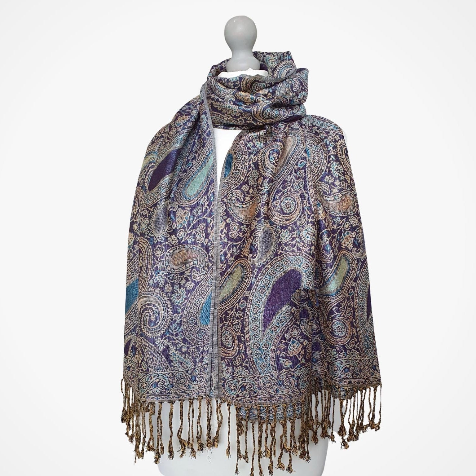 Patterned scarf with fringes on a mannequin against a white background