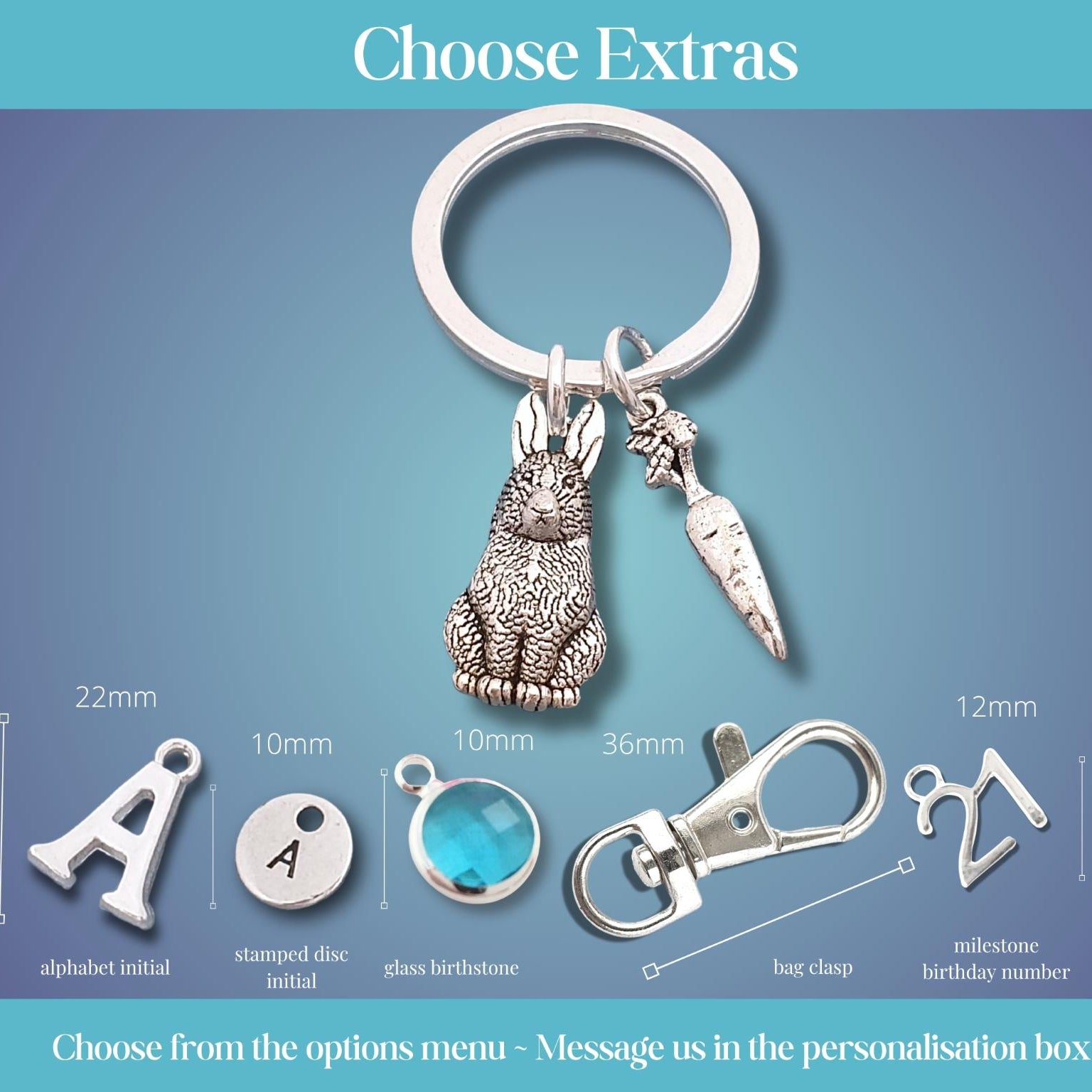 Personalized keychain customization options displayed on a blue gradient background, featuring a silver metal key ring with a rabbit and carrot charm, plus size and detail callouts for alphabet initial, stamped disc initial, glass birthstone, bag clip, and milestone birthday number extras.