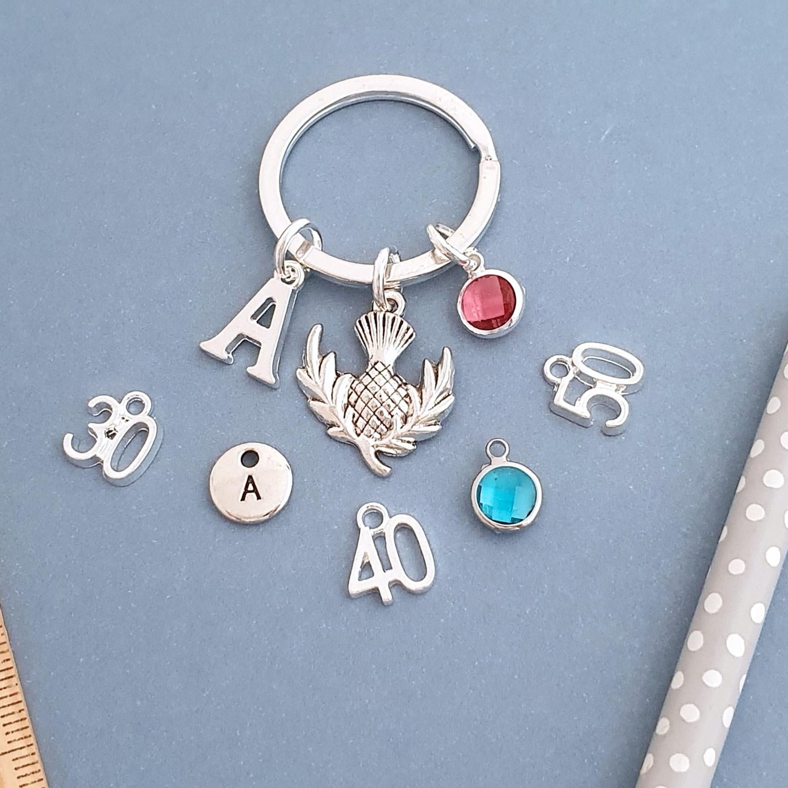 Silver keychain with various charms on a blue background