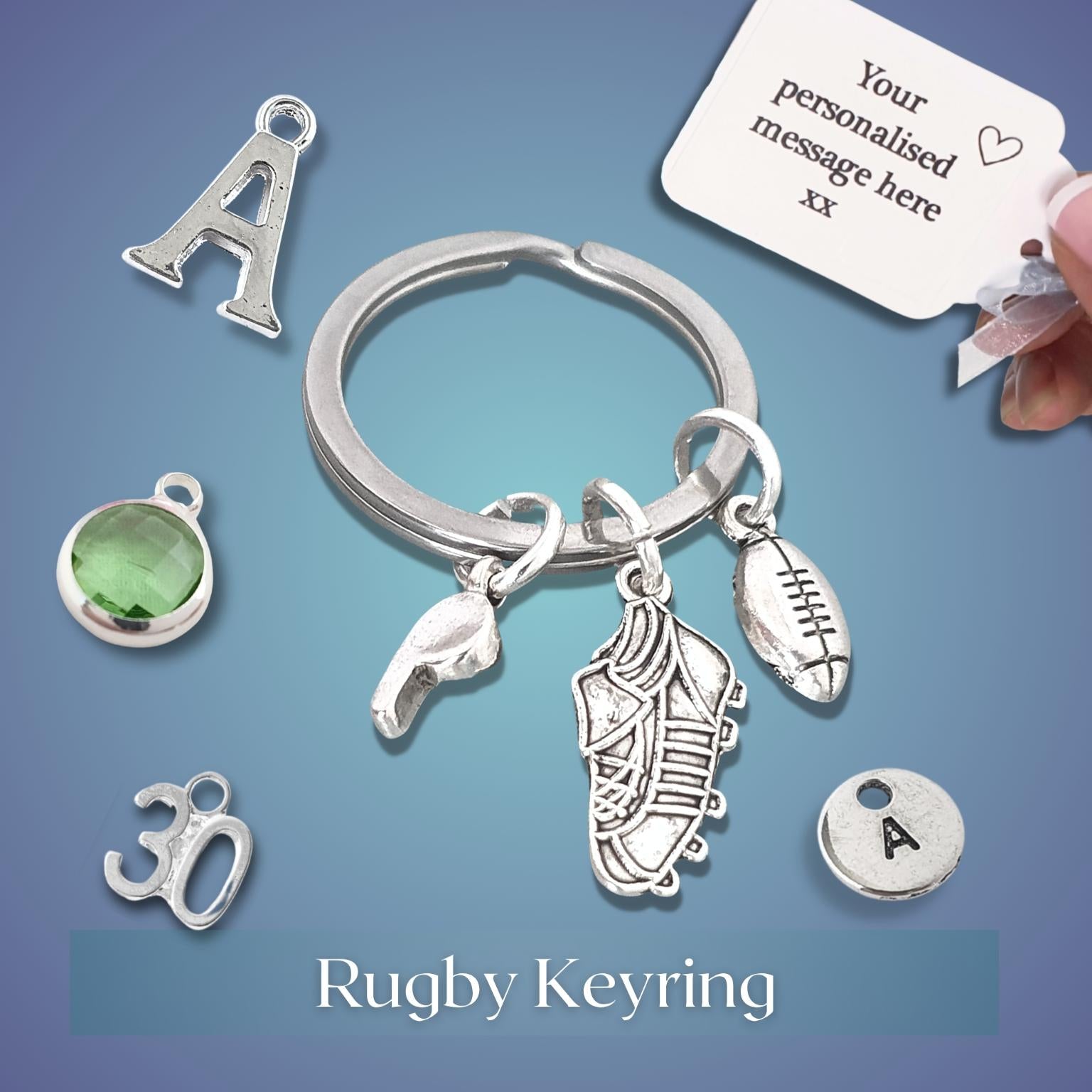 Silver keychain with various rugby themed charms including a rugby football, boot, and whistle on a blue background.