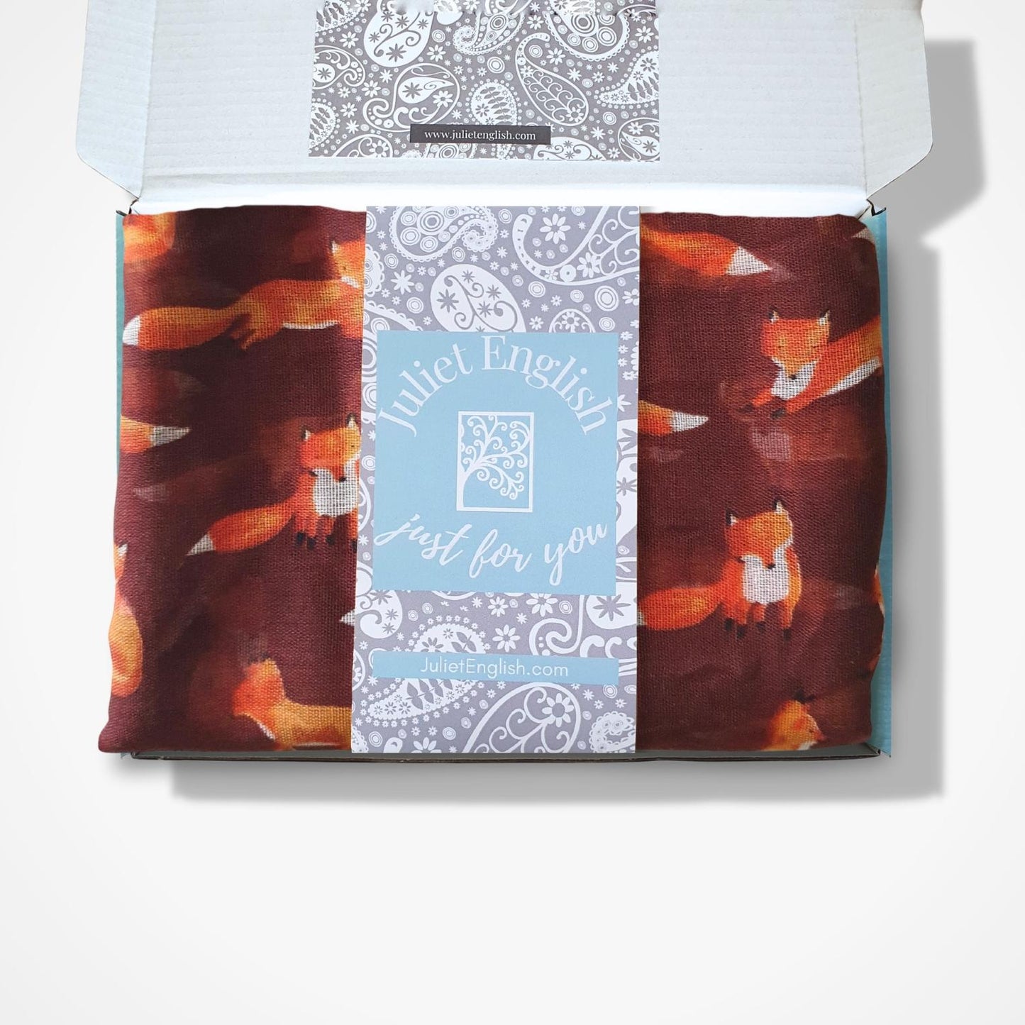 Fox-patterned scarf in a box with a visible brand label.