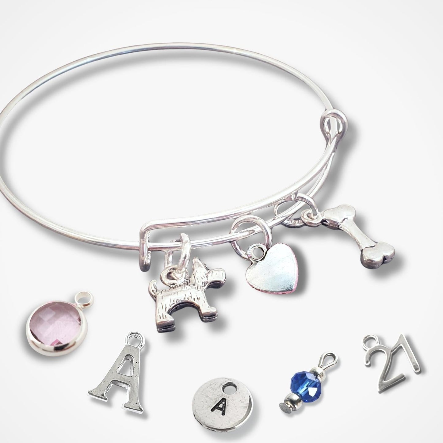 Silver bracelet with various scotty dog theme charms on a white background