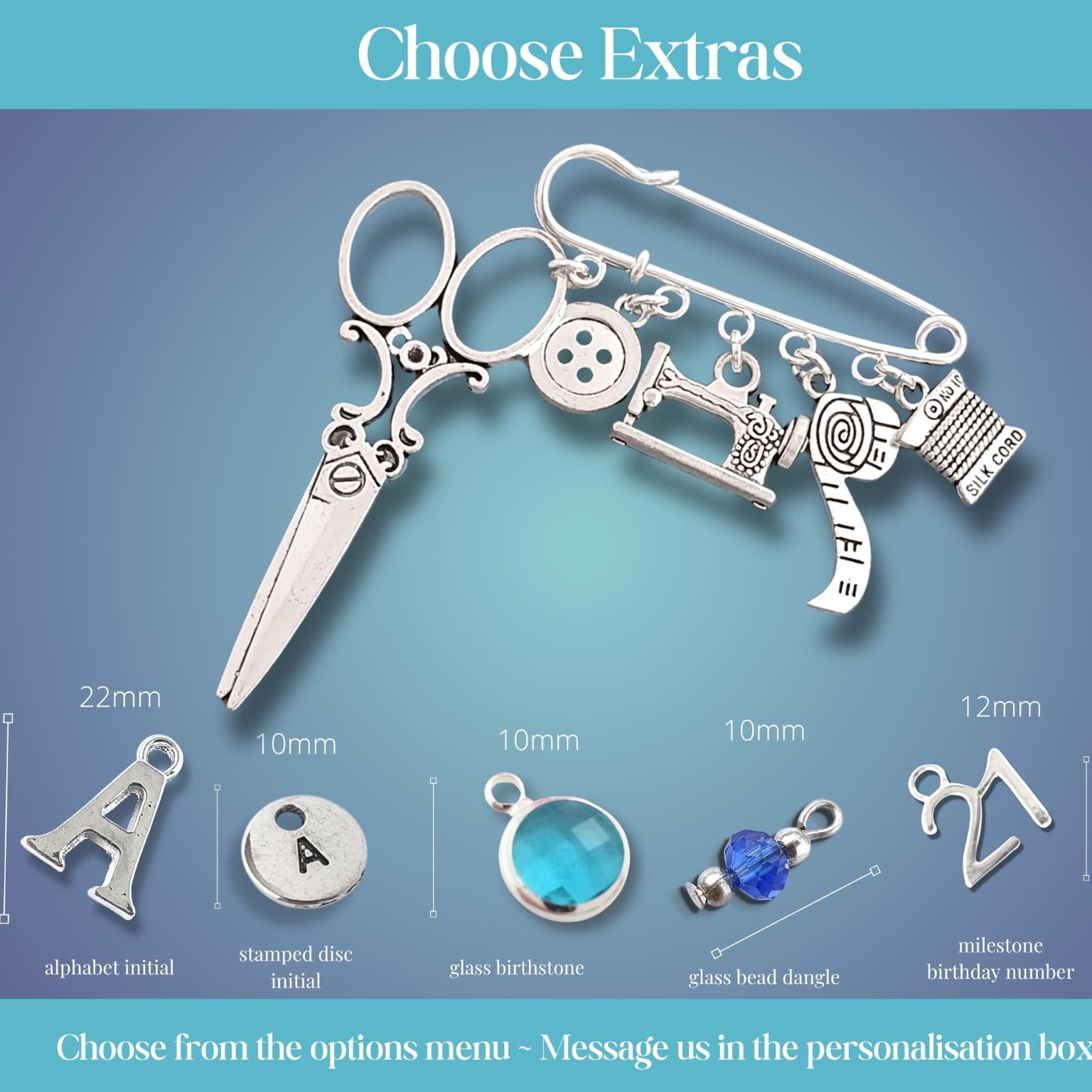 Brooch with sewing themed silver charms including scissors, sewing machine, buttons, and other items on a blue gradient background.