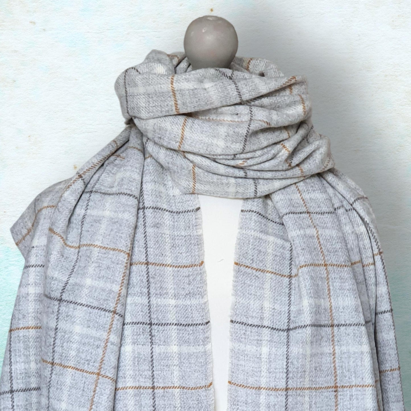 Plaid scarf on a mannequin against a light background