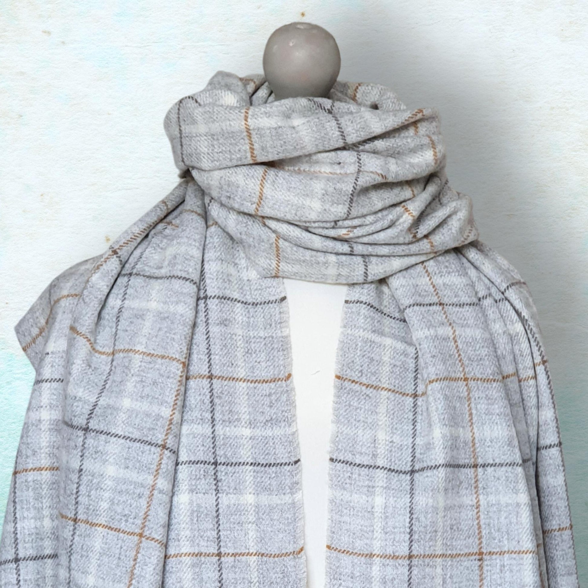 Plaid scarf on a mannequin against a light background