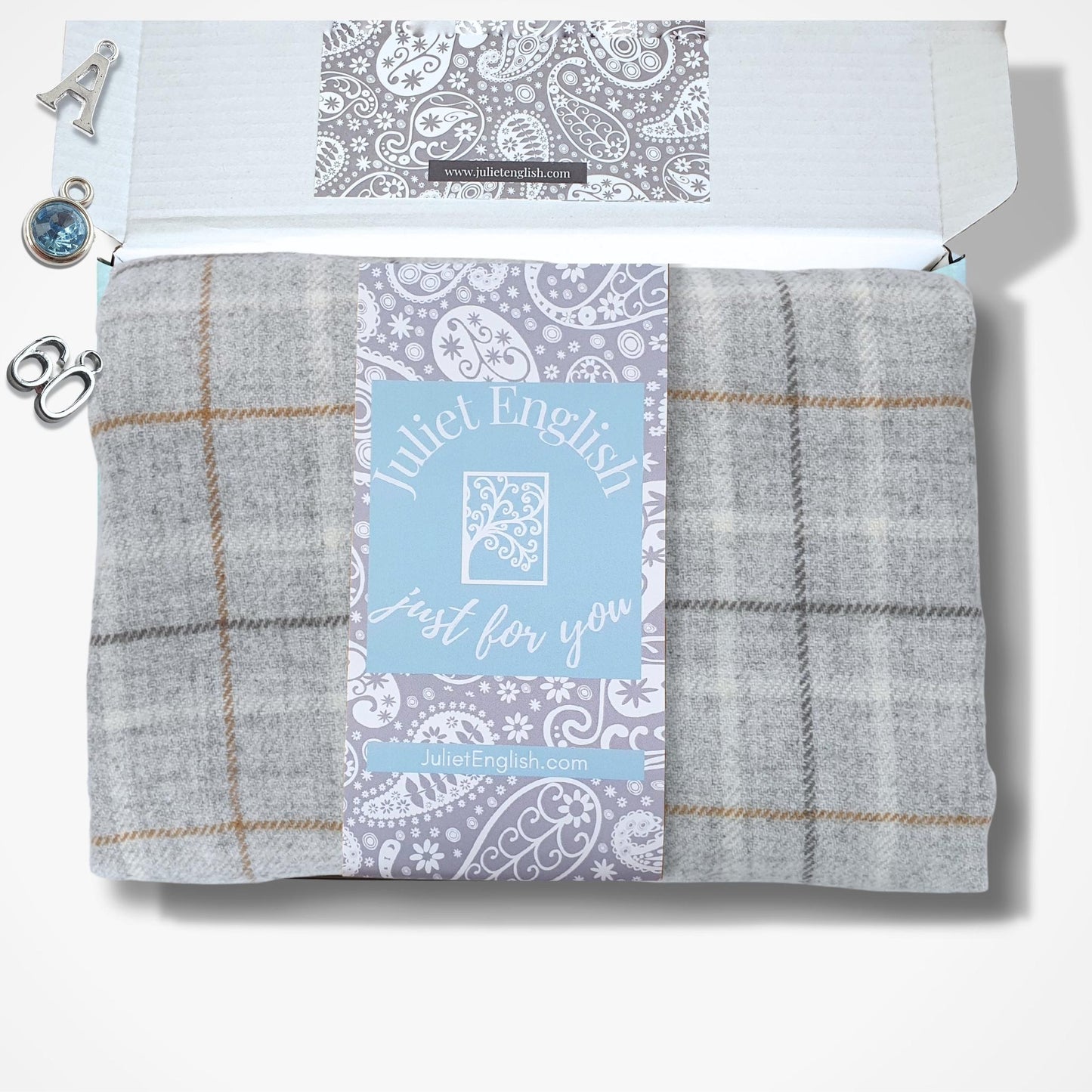 Folded scarf with plaid pattern and 'Juliet English' label in a box on a white background