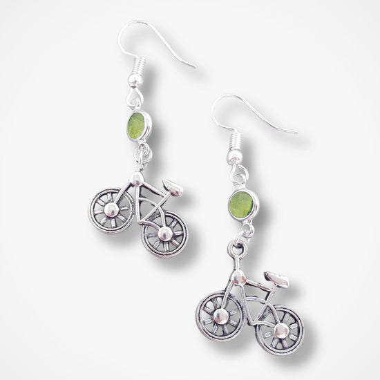 Silver bicycle-shaped earrings with green beads on a white background