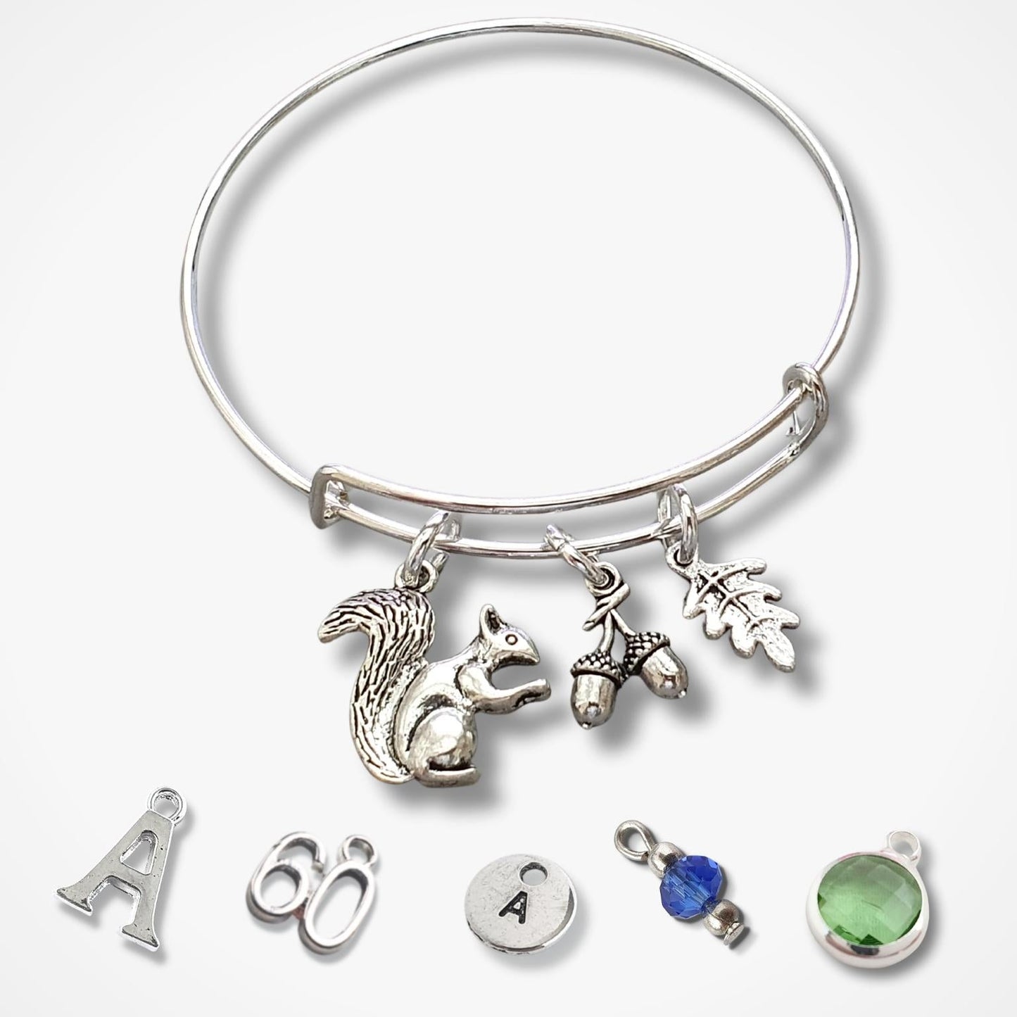 Silver adjustable bracelet with woodland charms on a white background