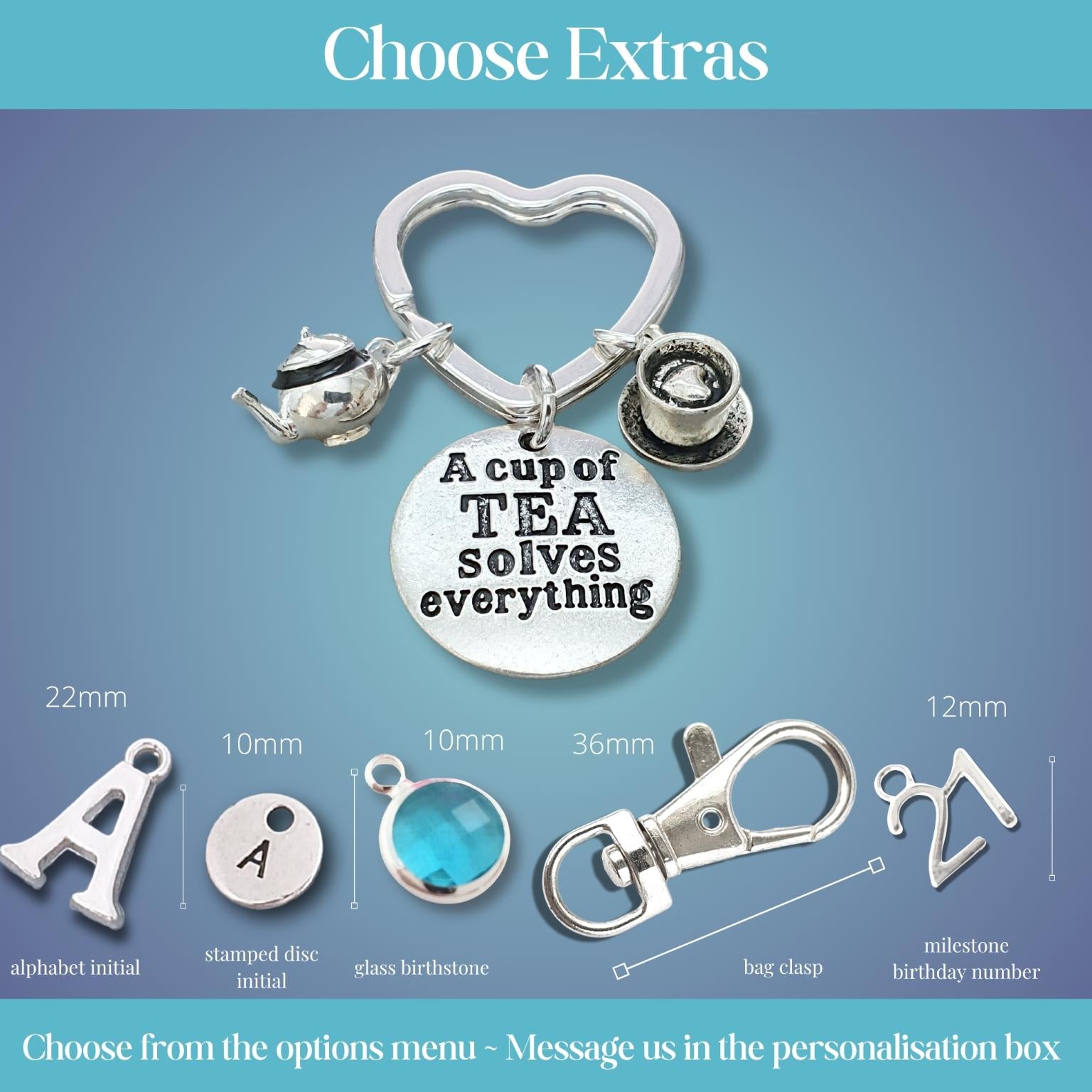 Personalised charm keychain customization options displayed on a blue gradient background, featuring a heart-shaped keychain with a teapot, coffee cup, and round charm engraved with 'A cup of TEA solves everything', plus dimensioned and labeled alternative charms and clasp options below.