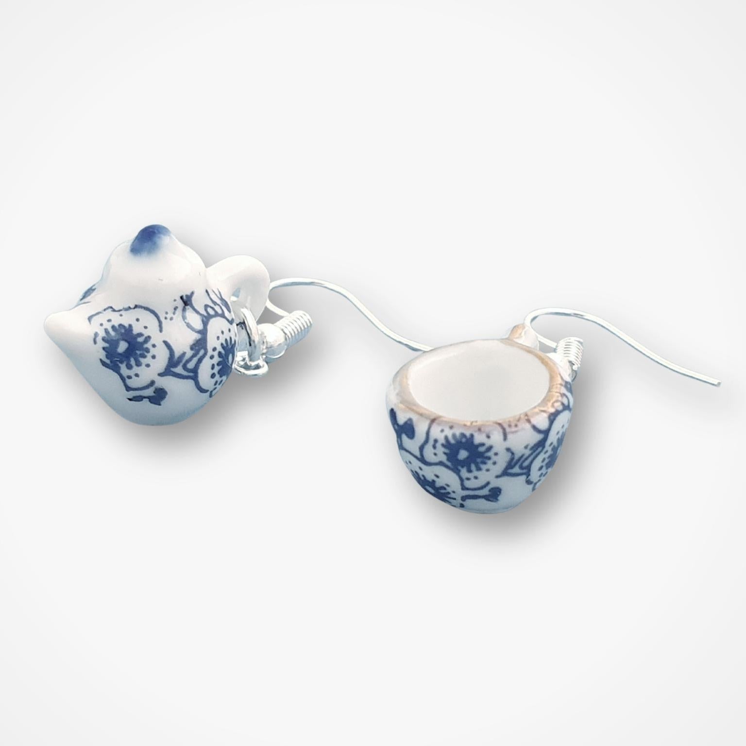 Pair of blue and white ceramic teapot and tea cup earrings on a white background