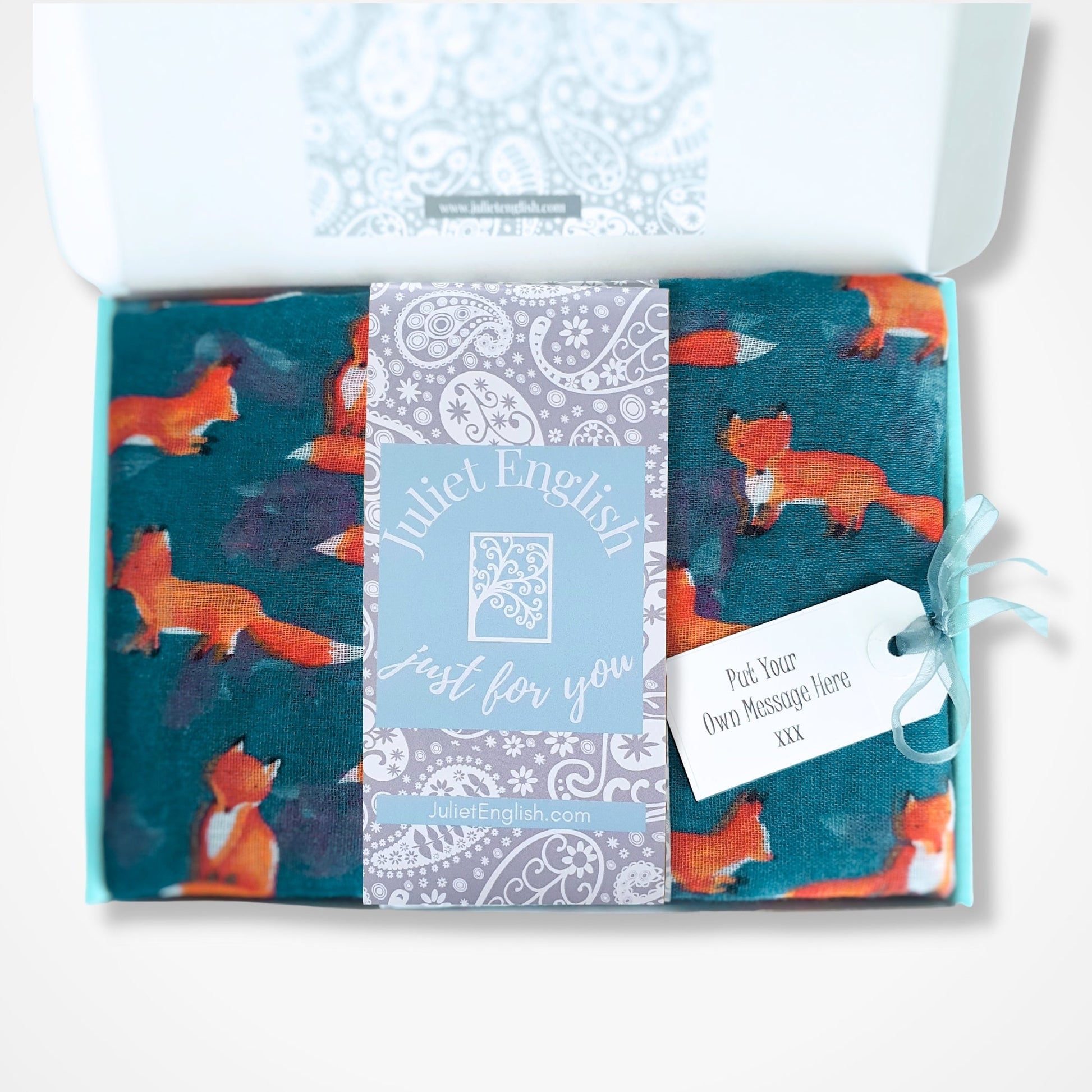 Gift box with fox-themed scarf in a box, featuring a gift tag.