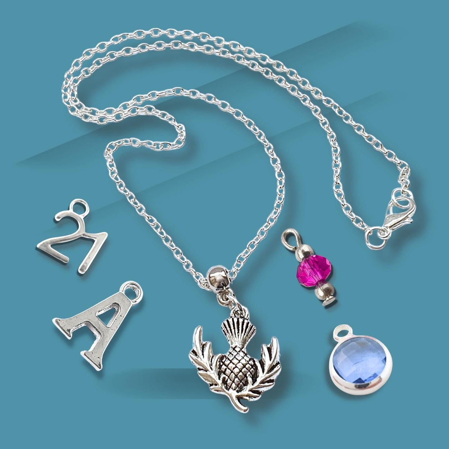 Silver necklace with various pendants on a blue background