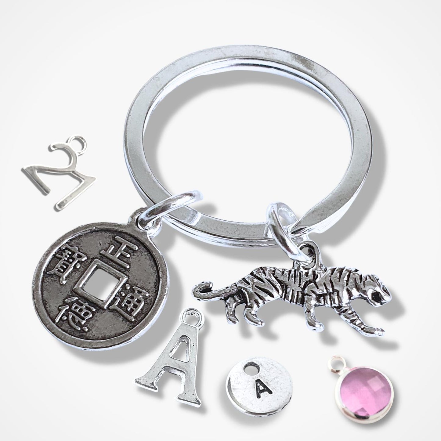 Silver keychain with various charms on a white background