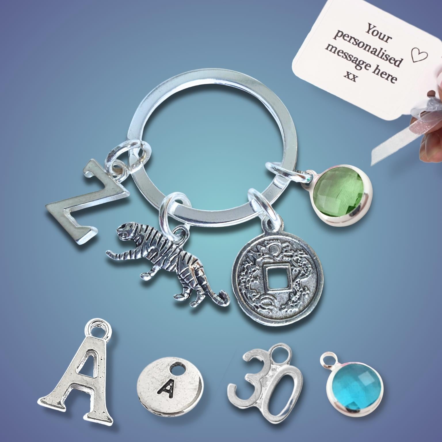 Silver keychain with tiger charm and coin charm and a customizable message card on a gradient background