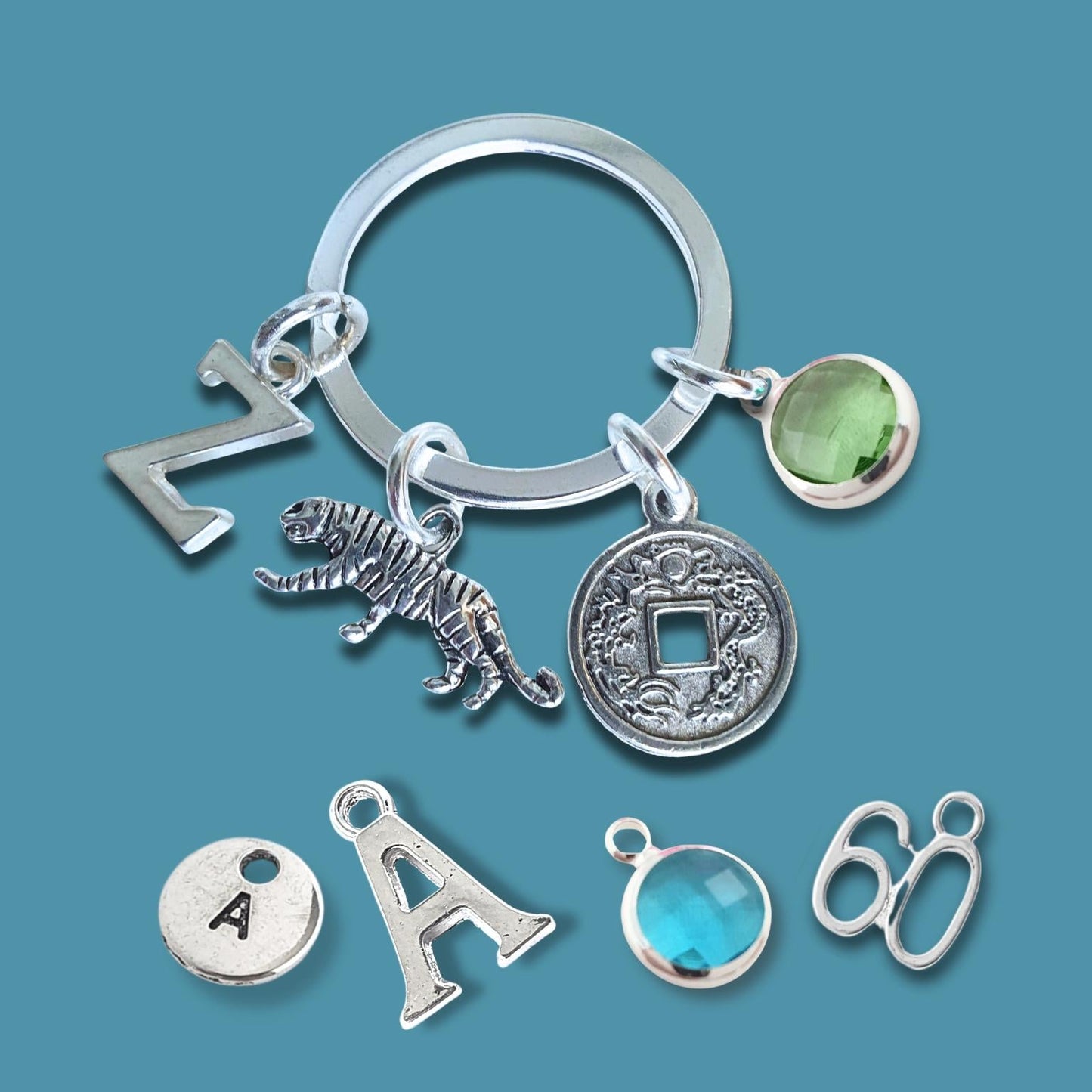 Silver keychain with tiger charm and coin charm on a blue background