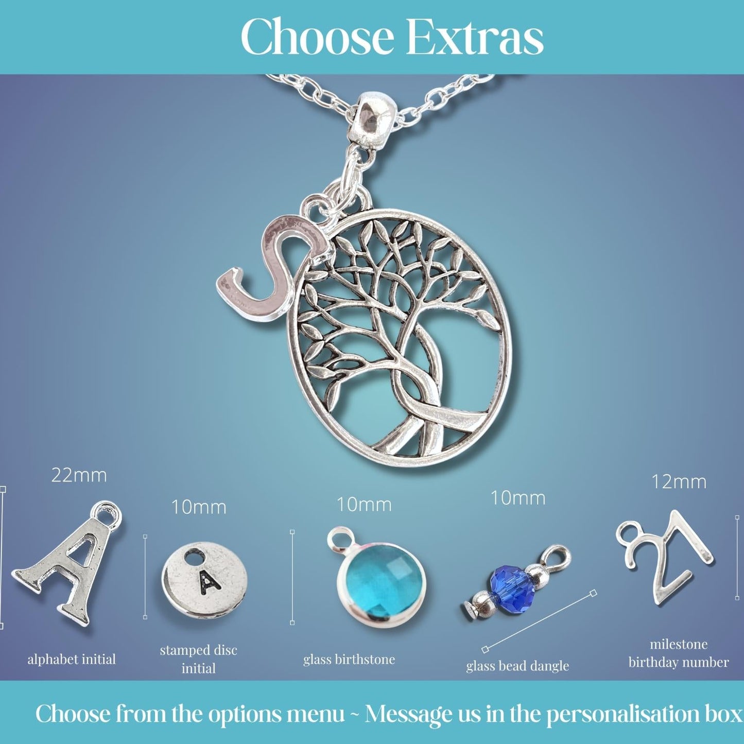 Silver tree of life pendant necklace on a chain with an extra initial charm, shown on a blue gradient background with size and material options labeled for alphabet initial, stamped disc initial, glass beadstone, glass bead dangle, and milestone birthday number personalisations.