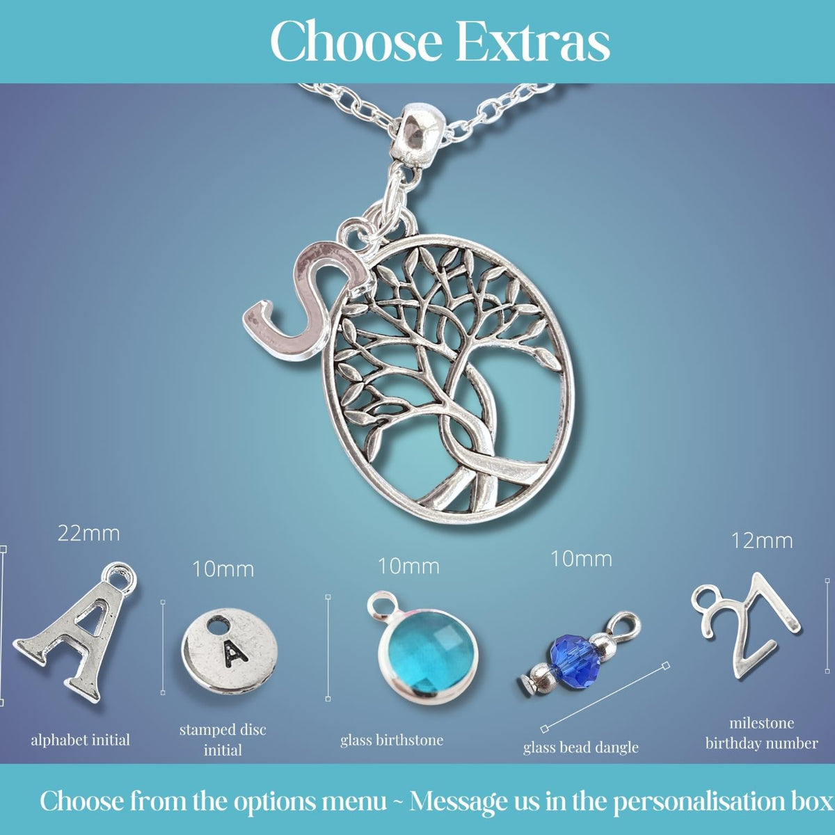 Silver tree of life pendant necklace on a chain with an extra initial charm, shown on a blue gradient background with size and material options labeled for alphabet initial, stamped disc initial, glass beadstone, glass bead dangle, and milestone birthday number personalisations.