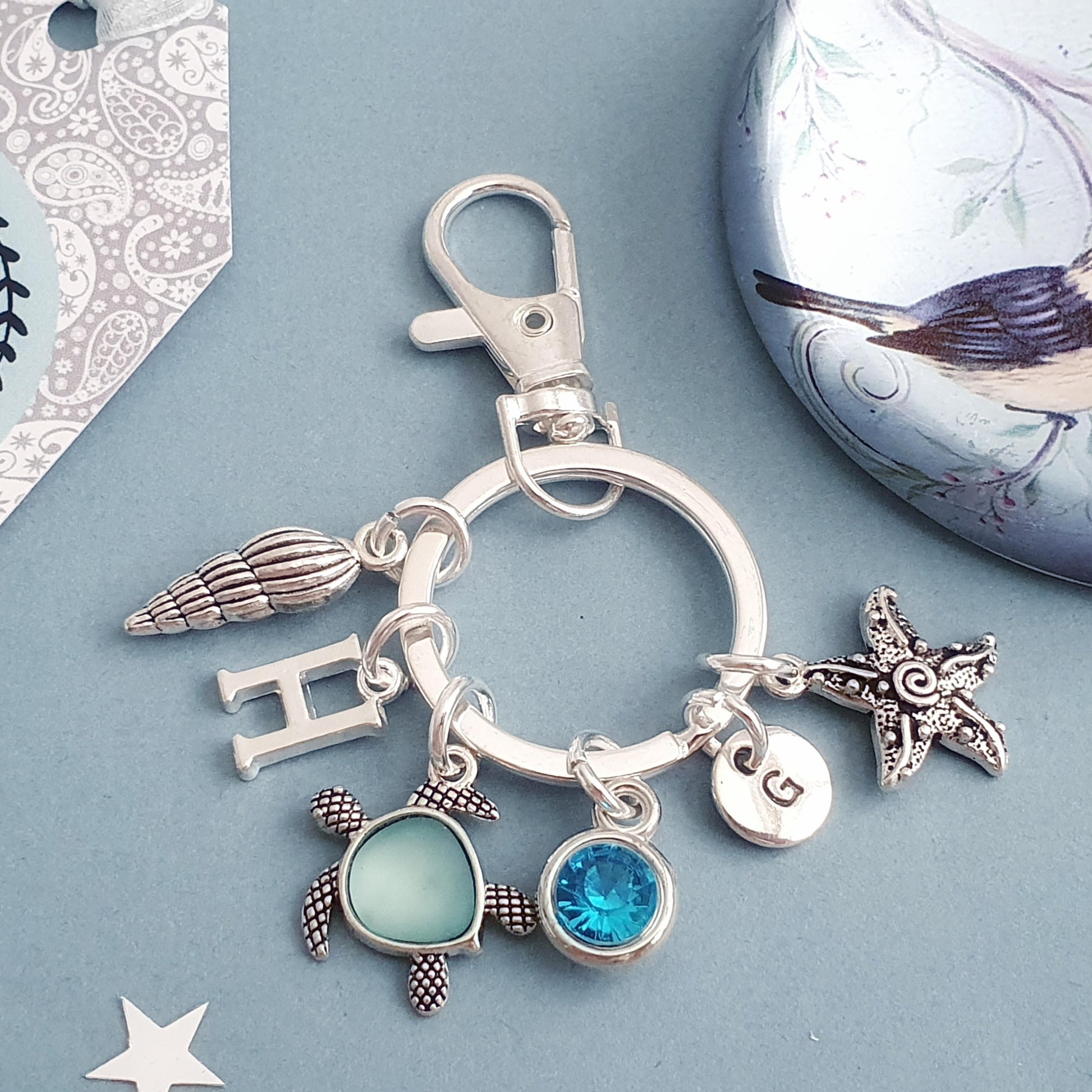 Silver keychain with various charms on a blue background