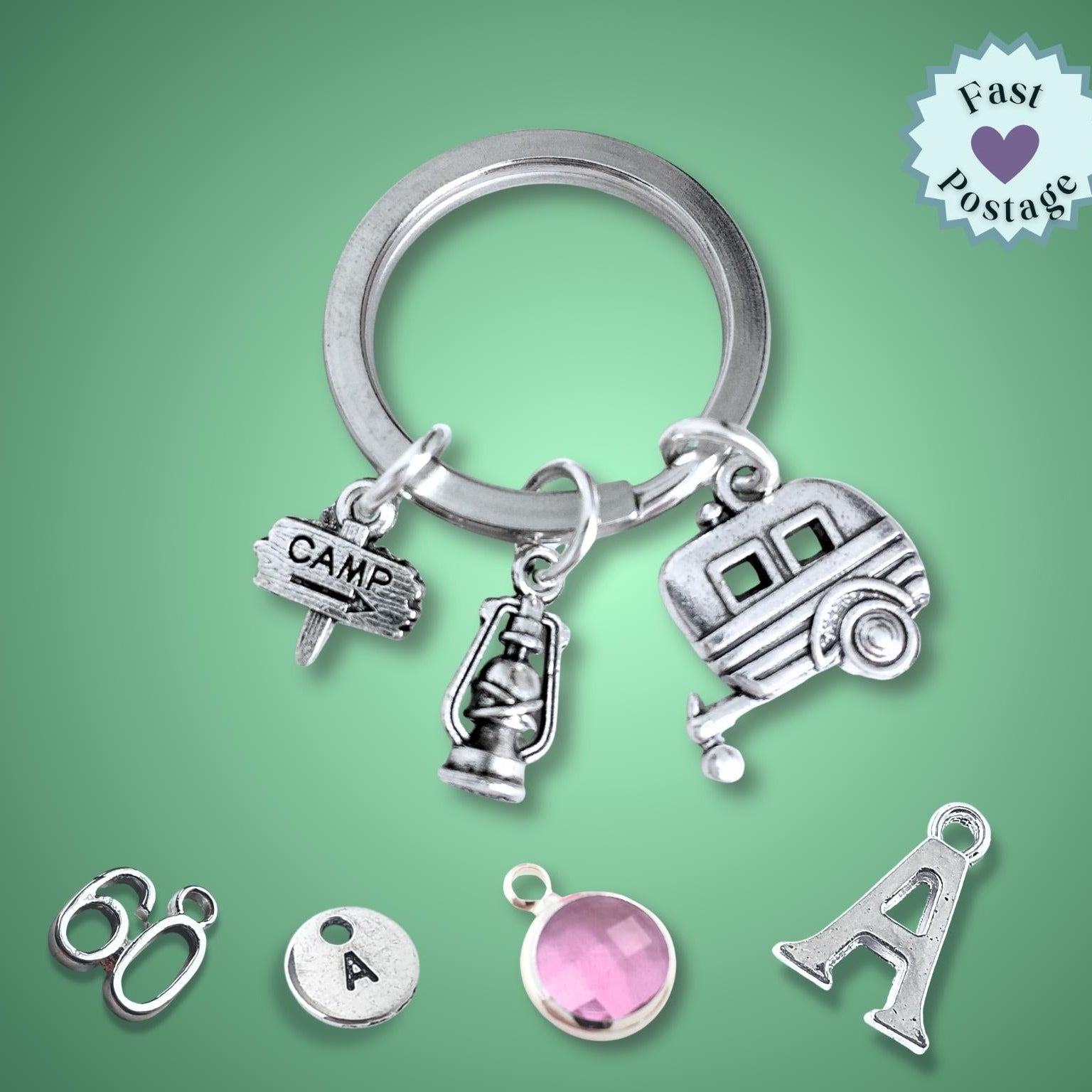 Silver keychain with caravan and camping charms on a green background