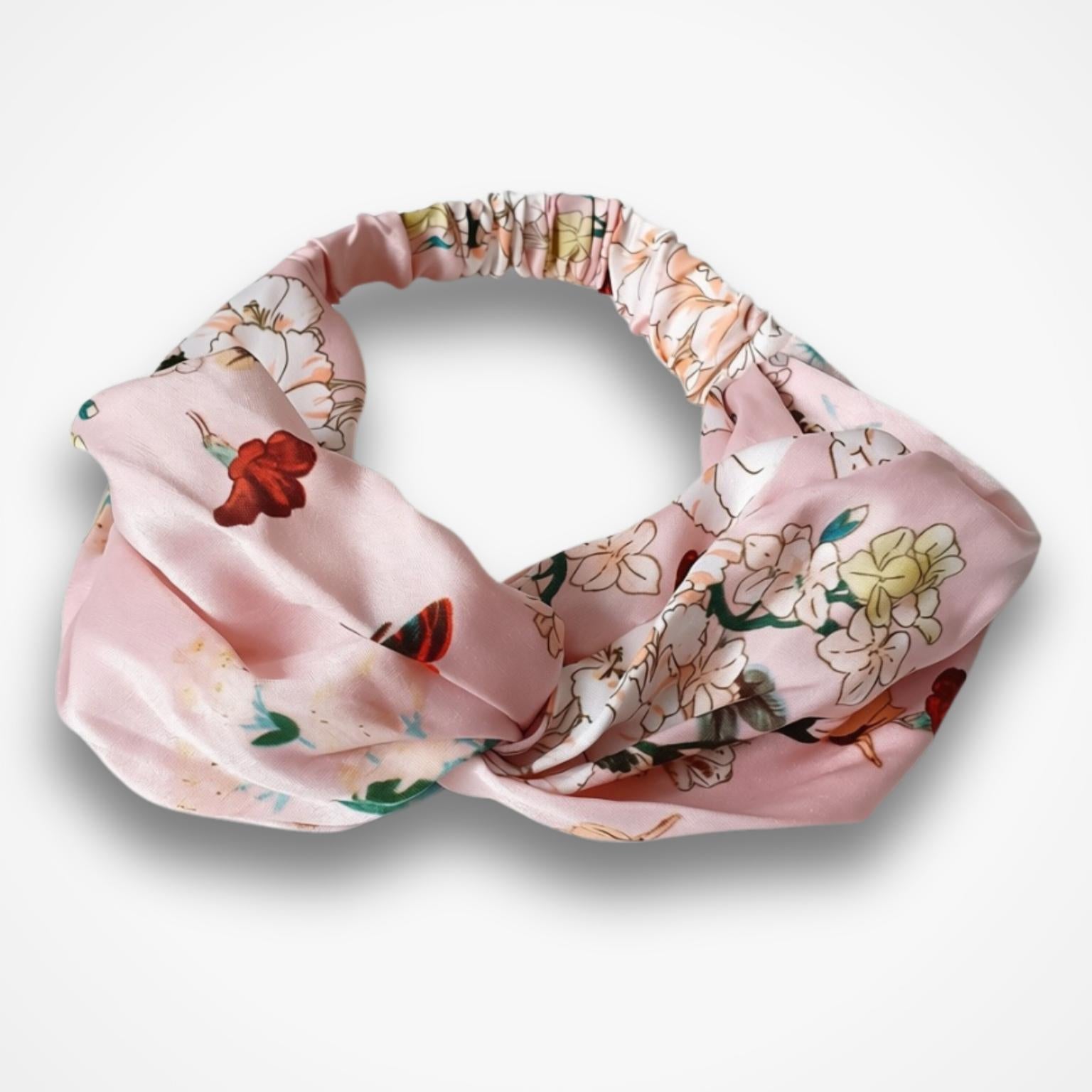 A pink knotted headband with a delicate floral and butterfly pattern, displayed on a clean white background.