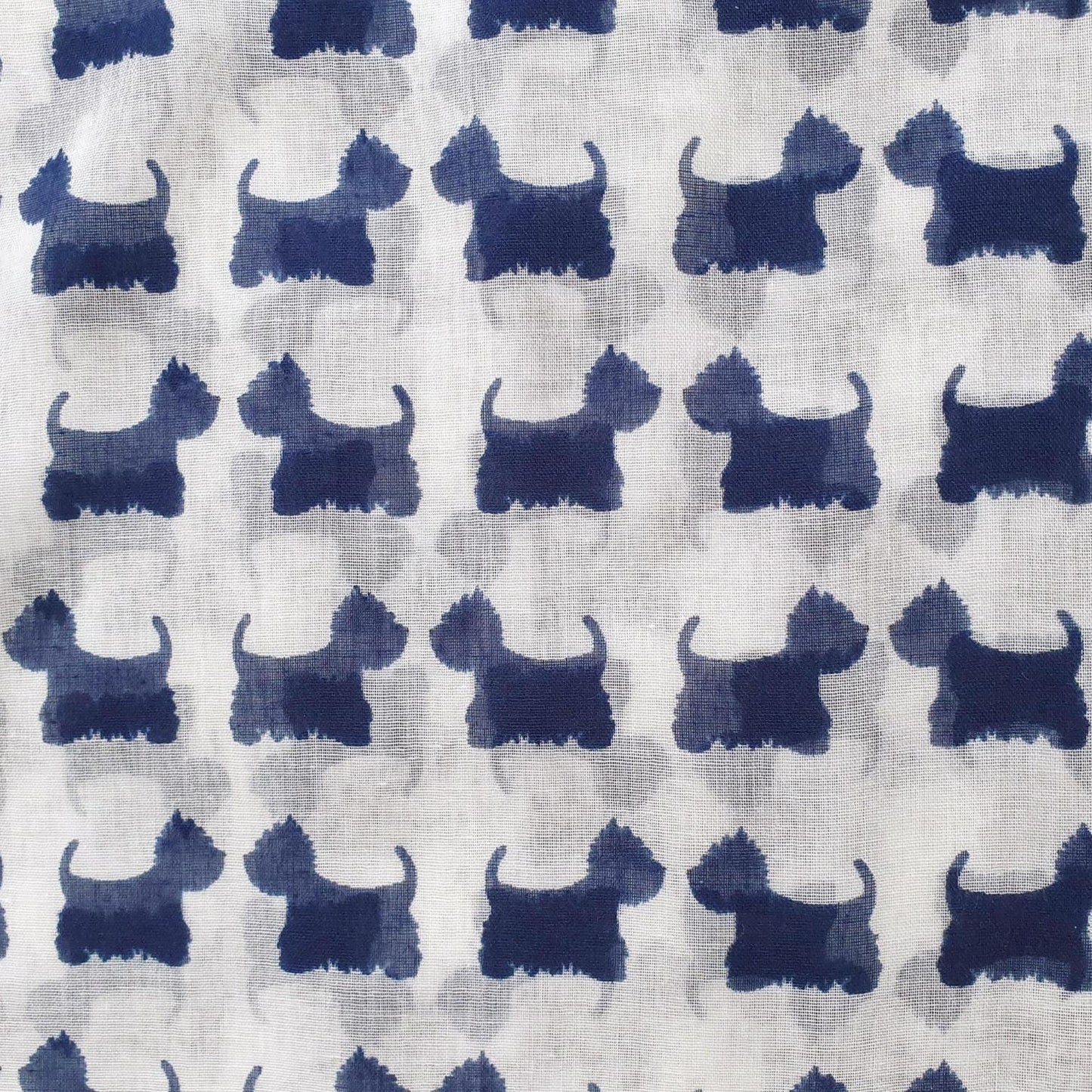 A close-up of a fabric pattern featuring repeating dark blue watercolor-style dog silhouettes on a light off-white background.