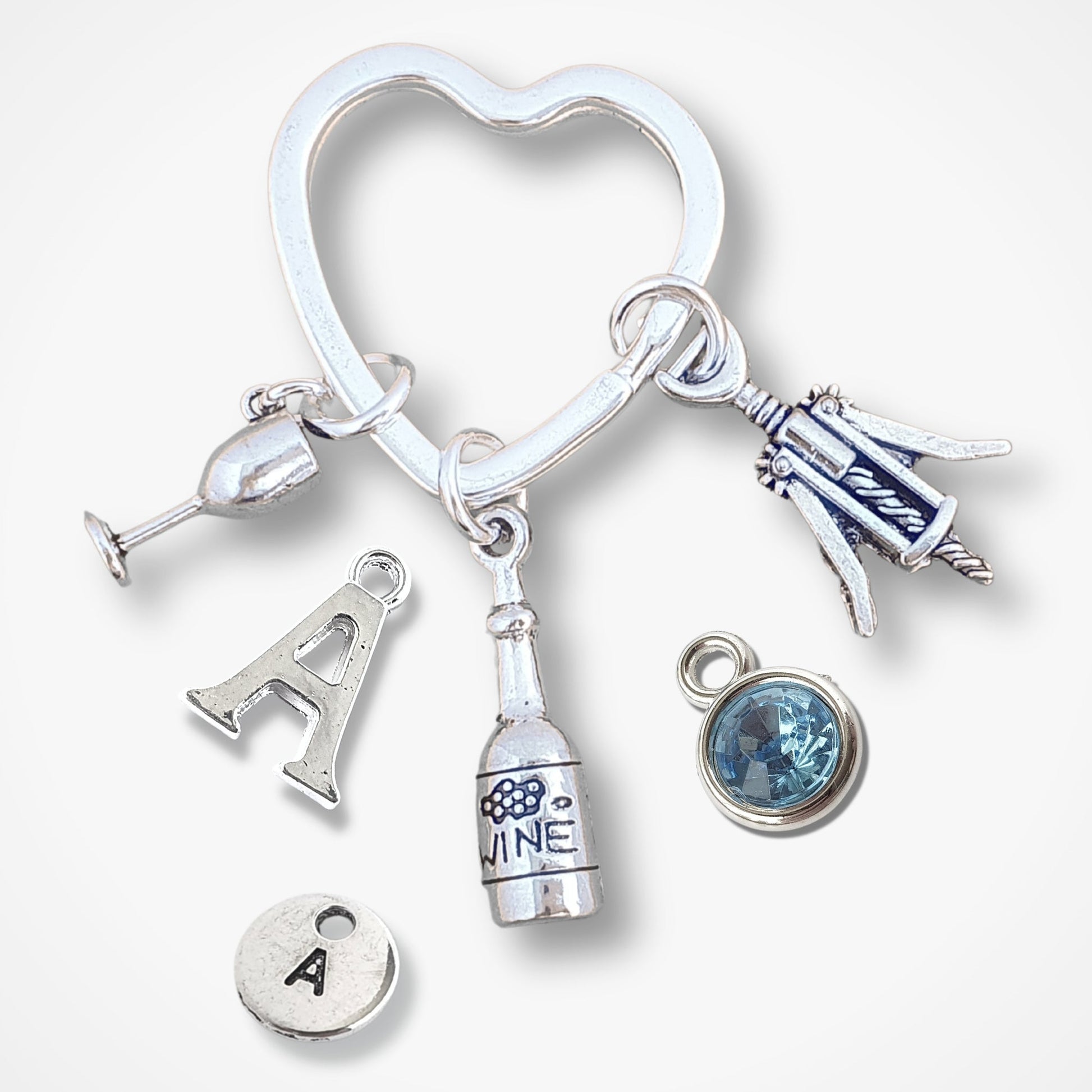 Silver keychain with heart-shaped design and various wine themed charms on a white background